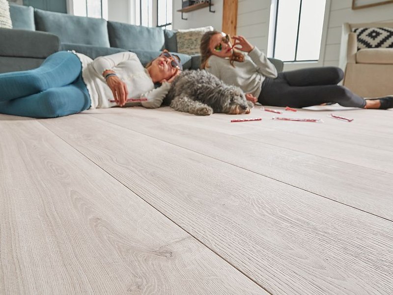 Teenagers laying on RevWood floor with dog